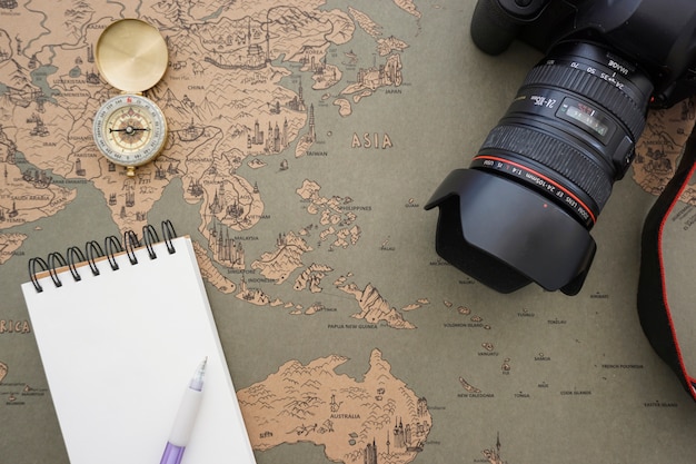 Бесплатное фото Ретро карта мира фон с пустой ноутбук и камеру