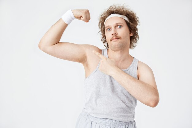 Retro young man in grey racerback tucked into pants