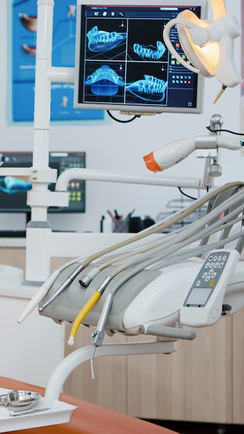 Revealing shot of stomatologist chair with nobody in, x ray images on display