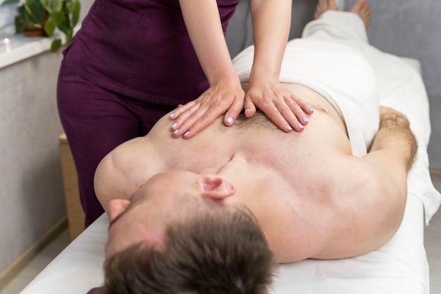 Восстанавливающий массаж мужской груди. оздоровительные процедуры в санатории. расслабляющее курортное лечение