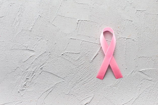 Ribbon of pink color on plaster background