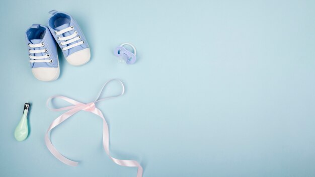 Ribbon with baby shoes copy space