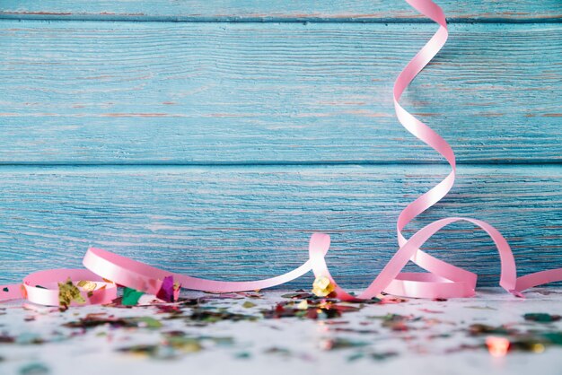 Ribbons and confetti on blue wood