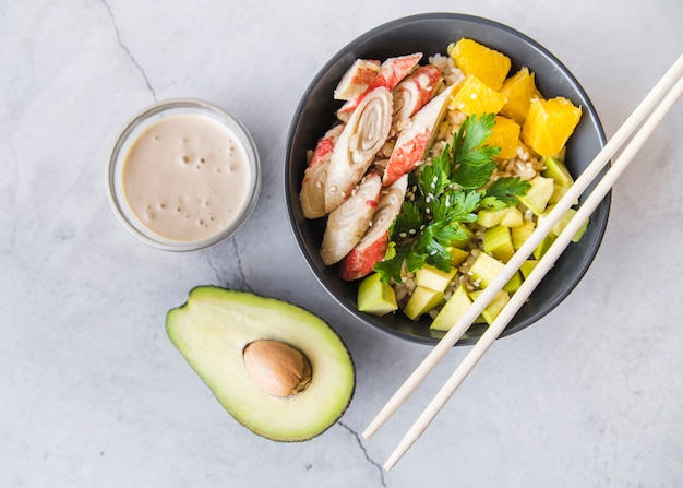 Free photo rice bowl with sauce and avocado