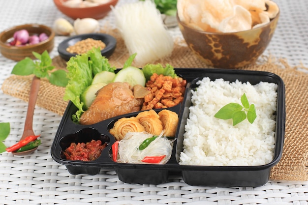 Коробка для риса или индонезийский наси котак с соевым соусом, куриным орегом, темпе и острой пастой
