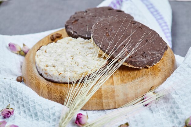 Rice and chocolate crackers on a wooden plate with a tablecloth.