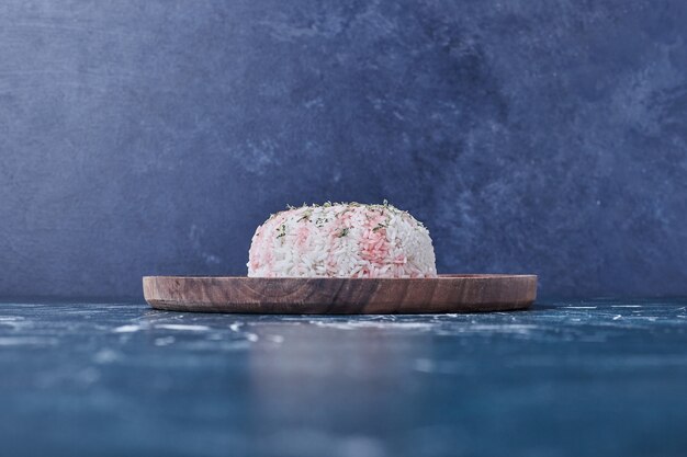 Rice garnish with lemon in a wooden platter.