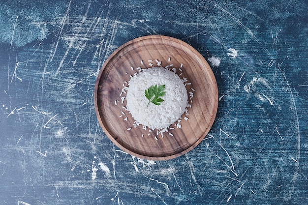 Guarnire il riso con prezzemolo in un piatto di legno.