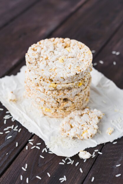 Rice grains and puffed rice cakes on paper over the desk