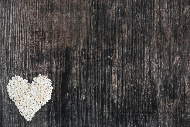 Rice heart shape made on wooden black backdrop