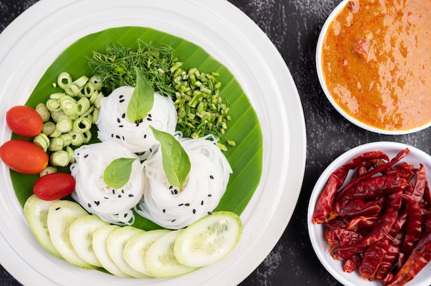 Free photo rice noodles in a banana leaf with beautifully laid vegetables and side dishes. thai food.