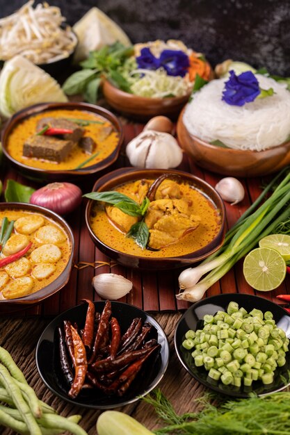 Rice noodles in a bowl of curry paste with chili, cucumber, long bean, lime, garlic and spring onion