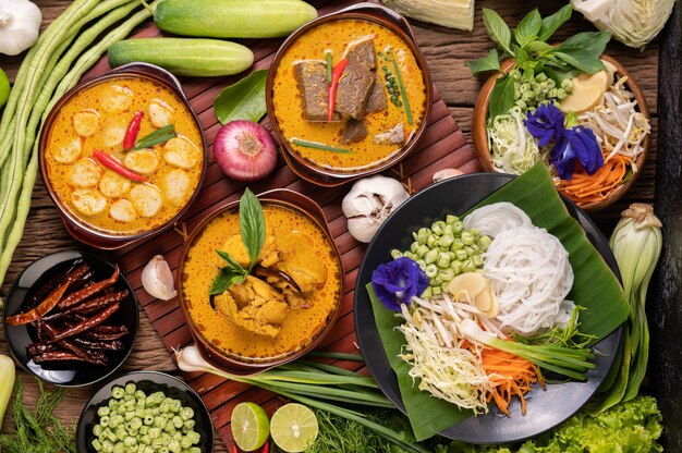 Rice noodles in a bowl of curry paste with chili, cucumber, long bean, lime, garlic and spring onion