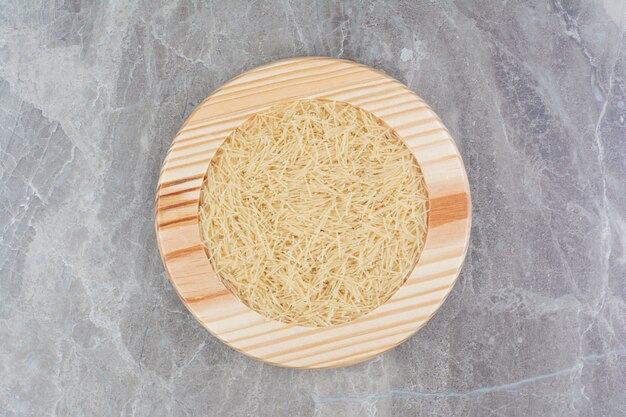 Рисовые макароны в круглом деревянном блюде