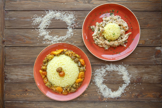 Foto gratuita piatti di riso con carne e frutta secca e pollo e funghi cremosi