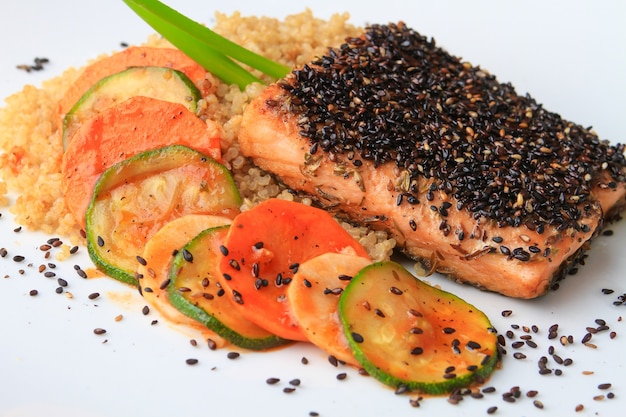 Foto gratuita riso, salmone e verdure decorate con semi di chia servite su un piatto bianco