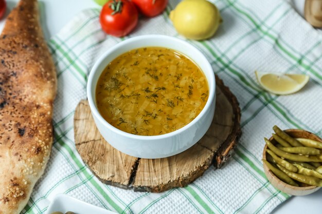 Рисовый суп в миске на деревянной доске с овощами