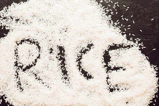 Rice text written in uncooked rice grain on textured background