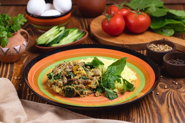 Rice with meat spinach eggs tomato spices greens side view