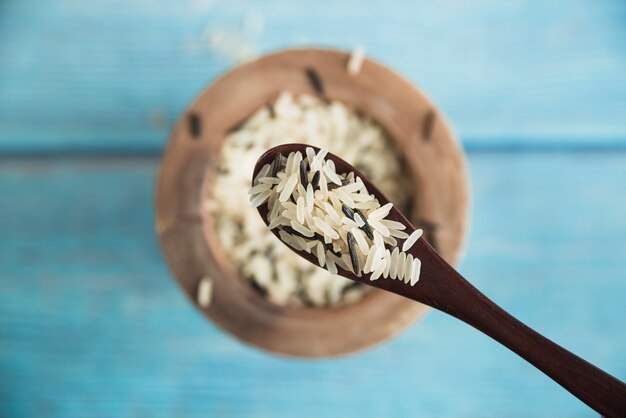 Rice on wooden spoon near bowl