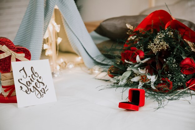 Ring and flowers near pile of presents