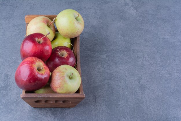 Ripe apples in box on the dark surface