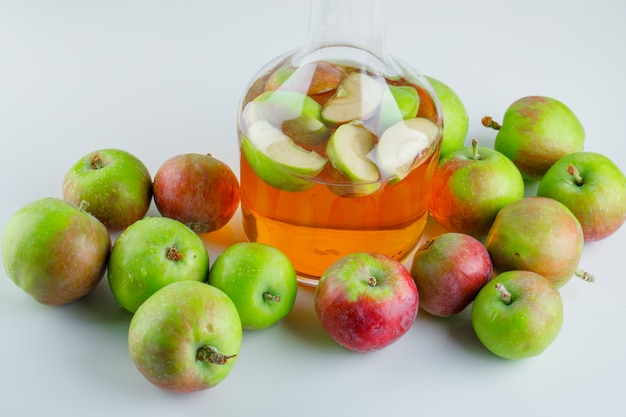 Ripe apples with drink high angle view on white