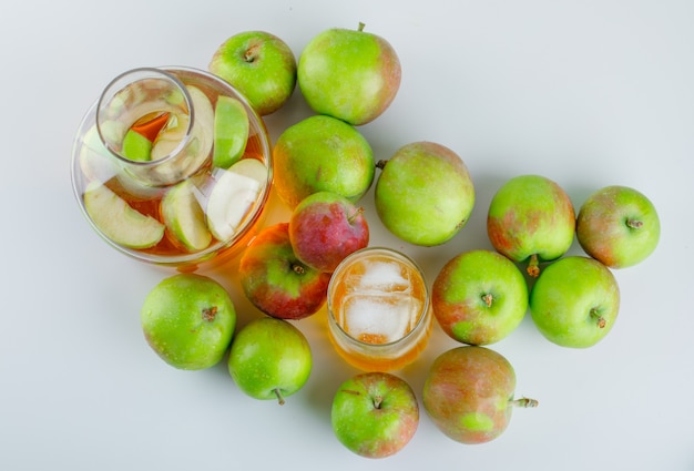 Ripe apples with icy drink on white