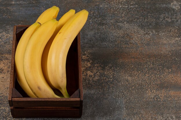 Ripe bananas in the box, on the marble surface