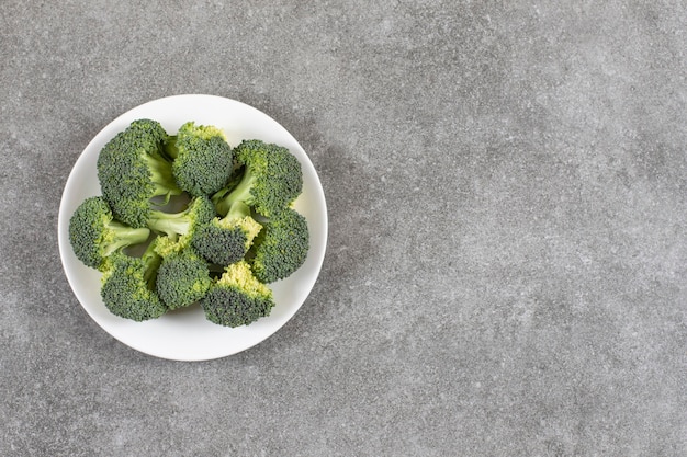 Free photo ripe broccoli on a plate, on the marble table.