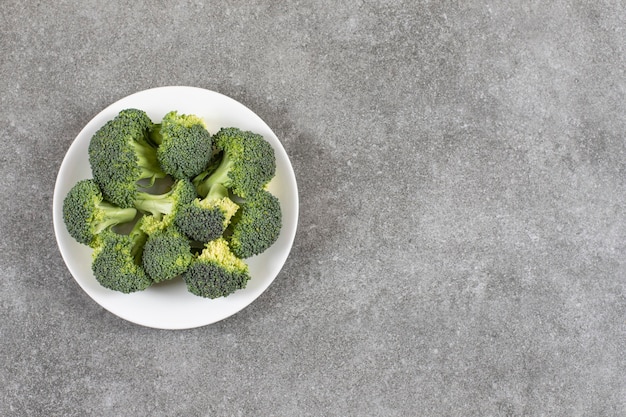Ripe broccoli on a plate, on the marble table. 