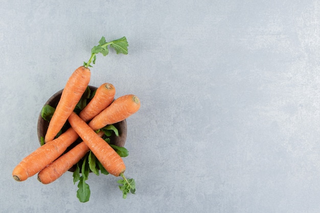 Free photo ripe carrots in the bowl , on the marble.