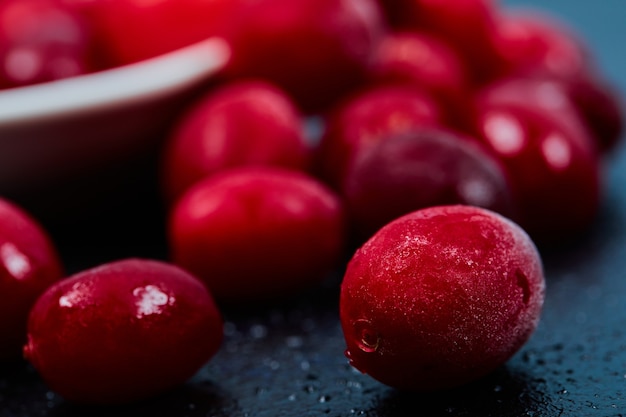 Ripe cornel berries on dark table. Close up.