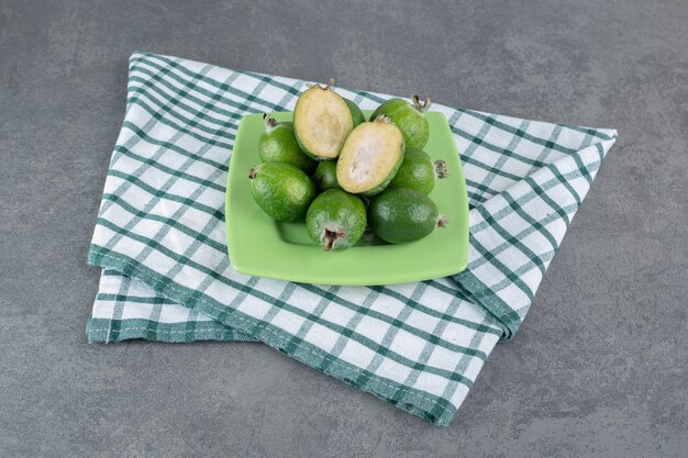 Frutti maturi di feijoa sul piatto verde. foto di alta qualità