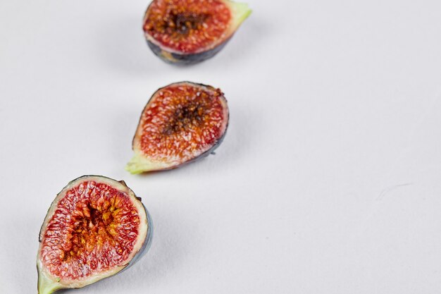 Ripe fig slices on white.