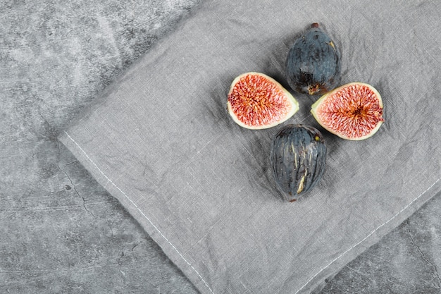 Free photo ripe figs on a marble surface with a grey tablecloth