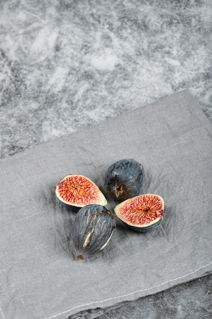 Free photo ripe figs on a marble surface with a grey tablecloth