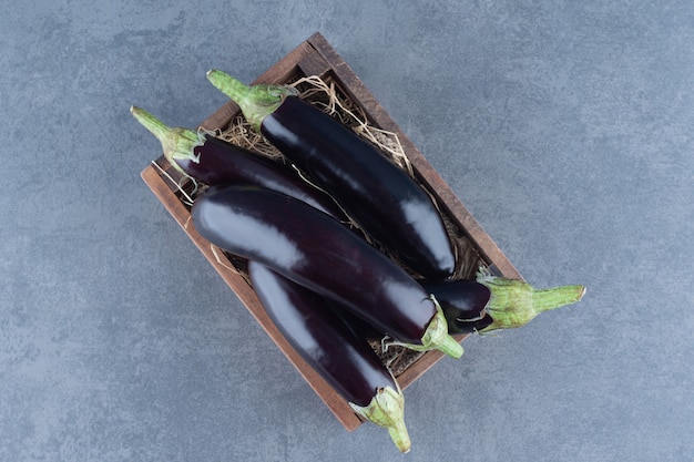 Free photo ripe fresh eggplants in wooden box.
