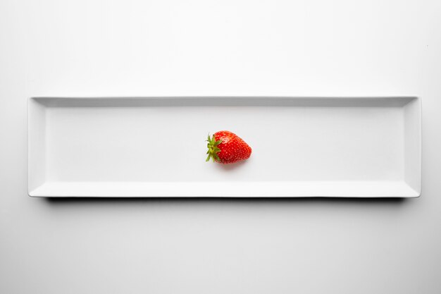 Ripe fresh juicy strawberry isolated on rectangular ceramic plate on white table background. Restaurant serving