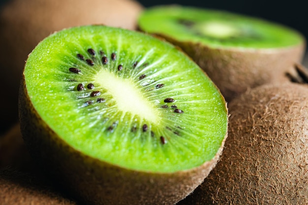 Foto gratuita frutti maturi di kiwi tagliati e interi da vicino