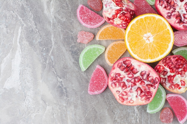 Free photo ripe fruits with candied fruits on marble surface