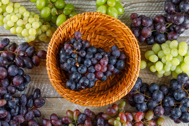 Ripe grapes in a wicker basket on a wooden background. flat lay.