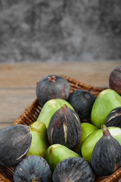 Ripe green and black figs in a basket.