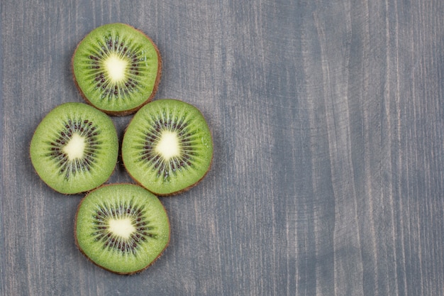 Free photo ripe kiwi fruit slices on wooden surface