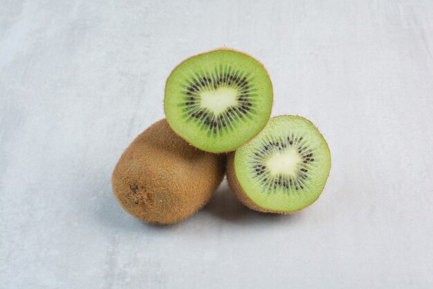 Ripe kiwi and slices on stone background