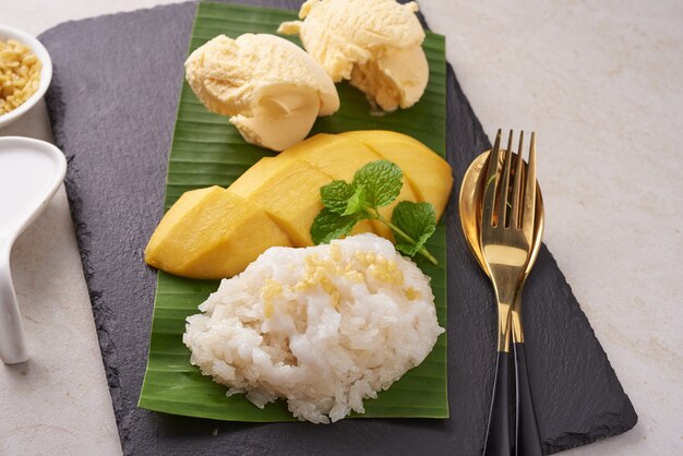 Ripe mango and sticky rice, Ice cream with coconut milk on stone surface, Thai sweet dessert on summer season. Tropical fruit.  Dessert fruit. top view.