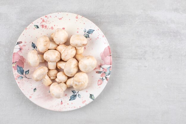 Free photo ripe mushrooms on a plate, on the marble table.