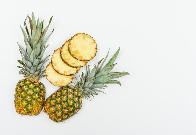 Ripe pineapple hala and slices flat lay on a white