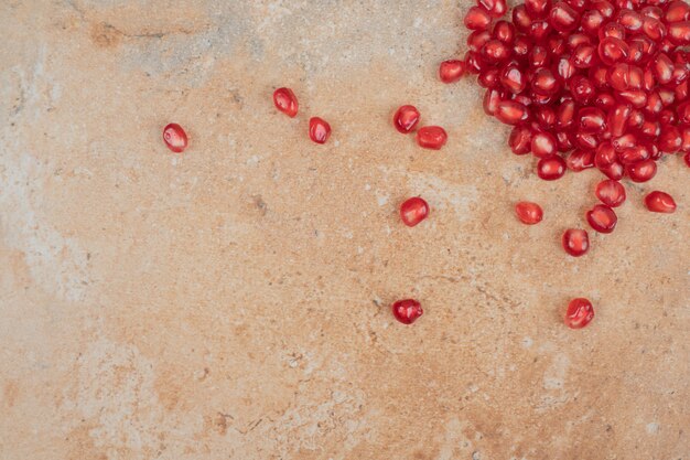 Ripe pomegranate seeds on marble background. 