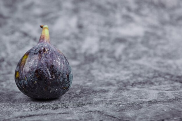 Ripe purple fig on a marble table.